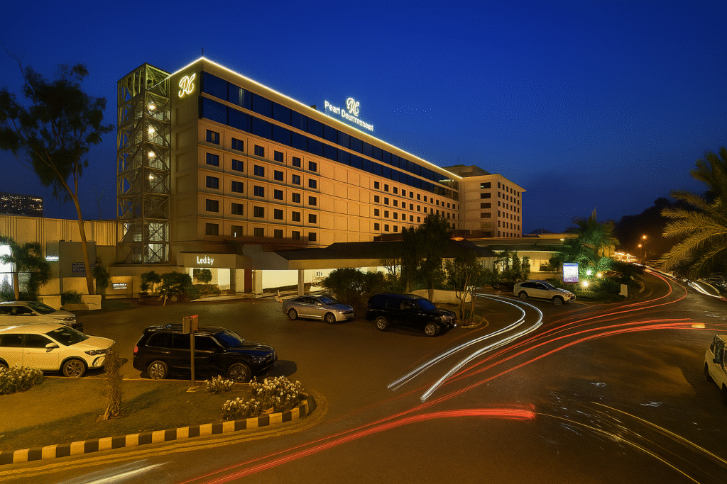 Night view of Pearl Continental Hotel Lahore with bright exterior lights, parked cars, and light trails, representing luxury and hospitality at one of the top hotels in Pakistan.